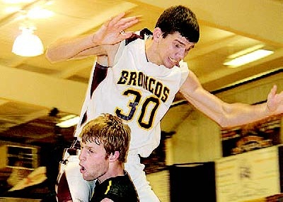 Florien’s Tyler Partridge takes a charge from Simpson’s Karsen Kelly (30) during first-half action last week in Hall of Fame play at Anacoco High School.