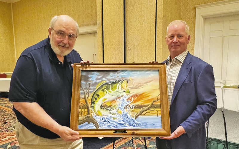 Stacy Floyd of Jena was the successful bidder on “Get the Net!” by Artist Larry Riales, pictured on the left.