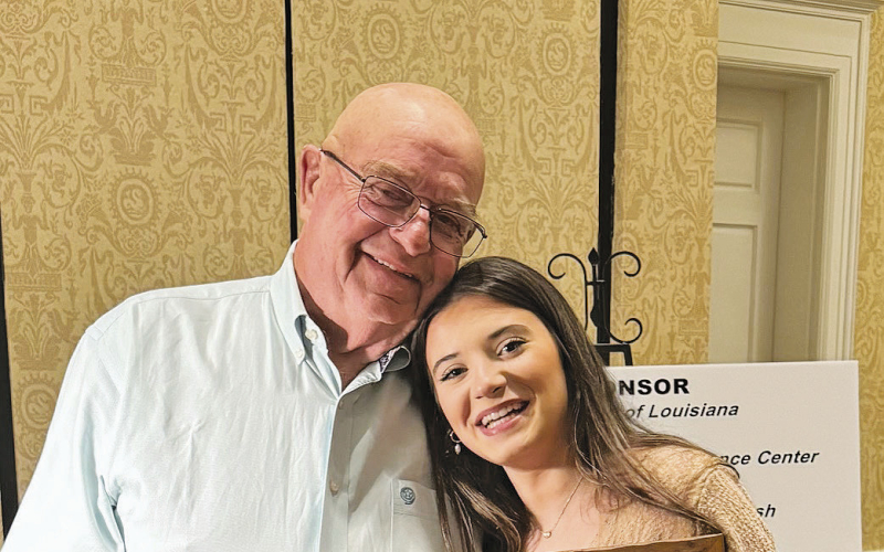 Florien High School Talented Art Student Aubree Leach is shown with her original painting “Bayou Bass” with the successful bidder Harlan Leach of Florien.