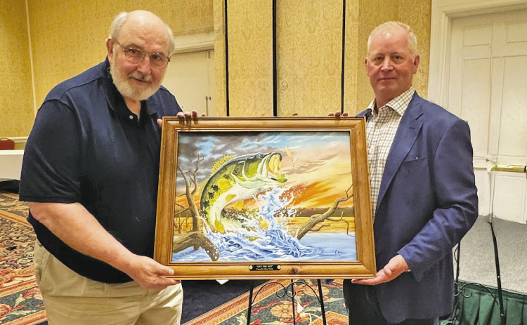 Stacy Floyd of Jena was the successful bidder on “Get the Net!” by Artist Larry Riales, pictured on the left.