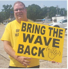 Proudly displaying one of his “Bring the Wave Back” signs is Chris Fertitta. He hopes this initiative will catch on and bring a degree of friendliness back to the local area (Photo by Daniel Jones/INDEX)