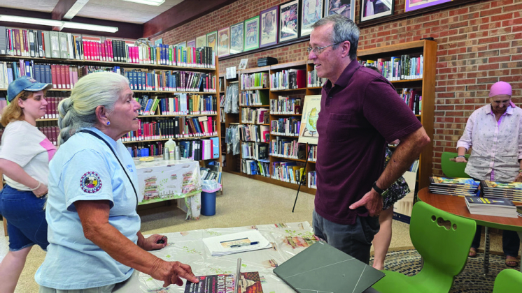 Rick Louden, at right, speaks with local resident Vickie Holbrook at the recent book signing (Photo by Sabine Index/Daniel Jones)