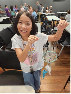 Yutai Yao proudly displays her handmade dream catcher at the interactive crafts workshop hosted by the Louisiana Folklife Center.