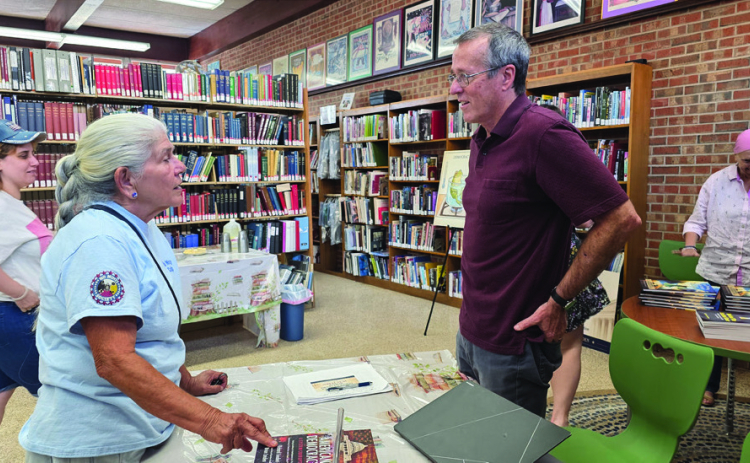 Rick Louden, at right, speaks with local resident Vickie Holbrook at the recent book signing (Photo by Sabine Index/Daniel Jones)