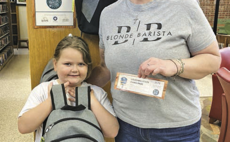Charli Thigpen and daughter Anna are the first library patrons to check out their state park pass and backpack.